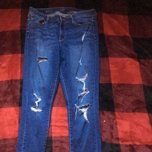 Blue ripped jeans, end are frayed and cutoff
